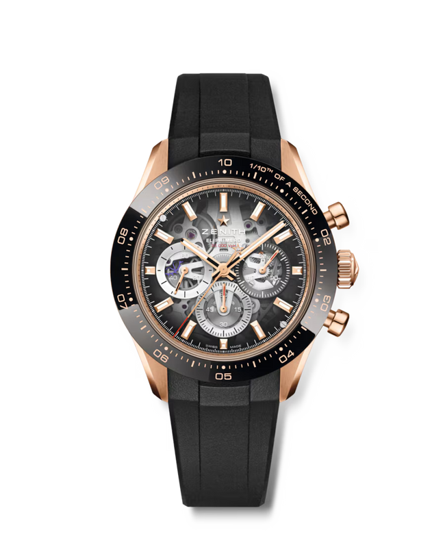 Rose gold chronograph watch with black dial, visible movement, black rubber strap, and tachymeter bezel.