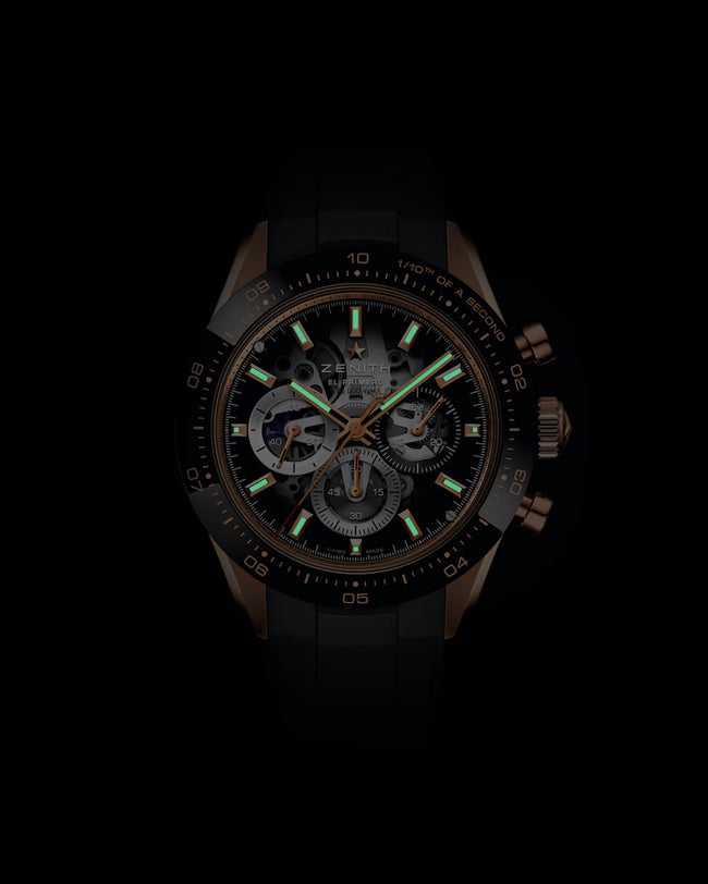 Chronograph watch with black dial, bronze case, luminous hour markers, and visible movement dial subdials.