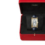 A Cartier Tank Américaine gold watch with a blue strap, presented in a red Cartier box lined with black velvet.