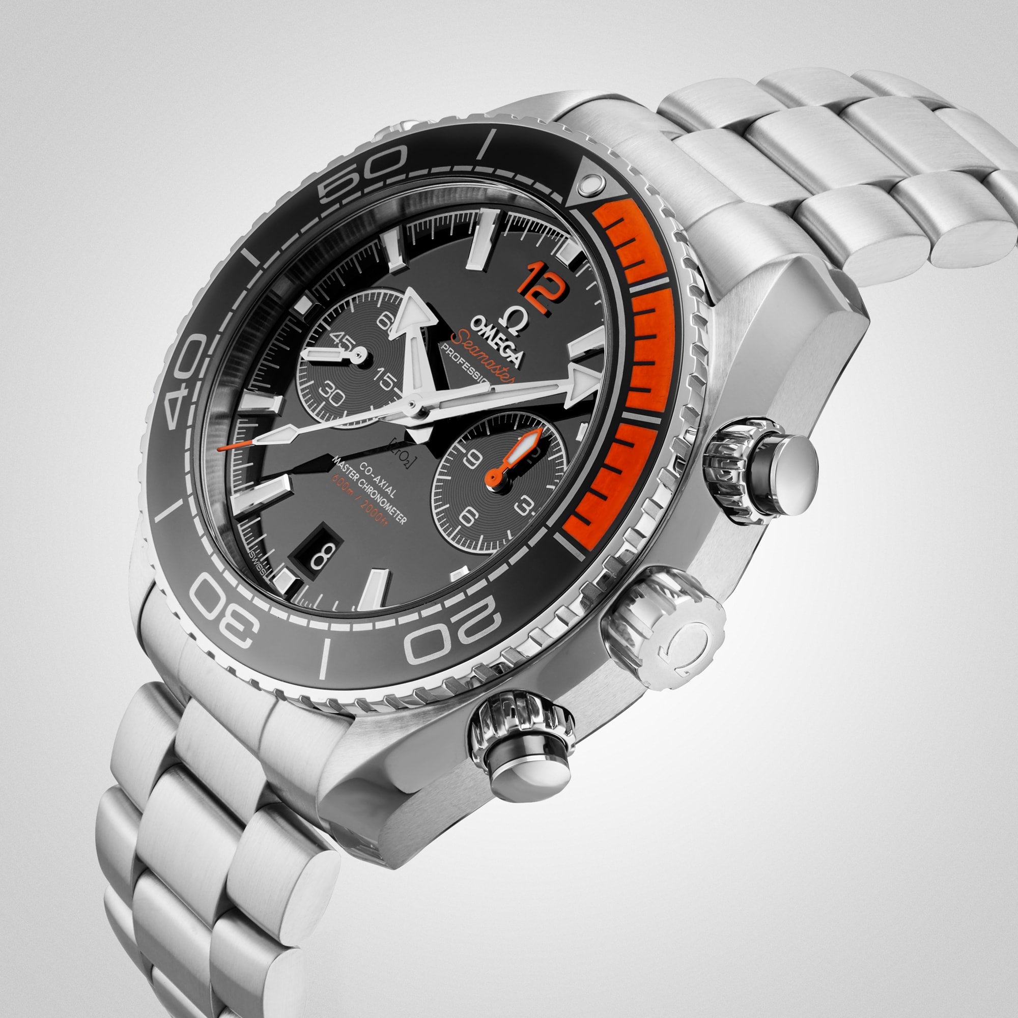 A close-up of an OMEGA Seamaster Planet Ocean 600M divers watch featuring a stainless steel case, black and orange bezel, three subdials, and a metal bracelet against a light gray background.