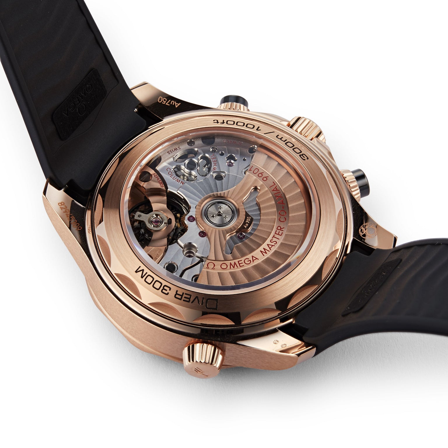 Close-up of the OMEGA Seamaster Diver 300Ms rose gold case back with a sapphire crystal revealing the mechanical movement, paired with a black rubber strap.