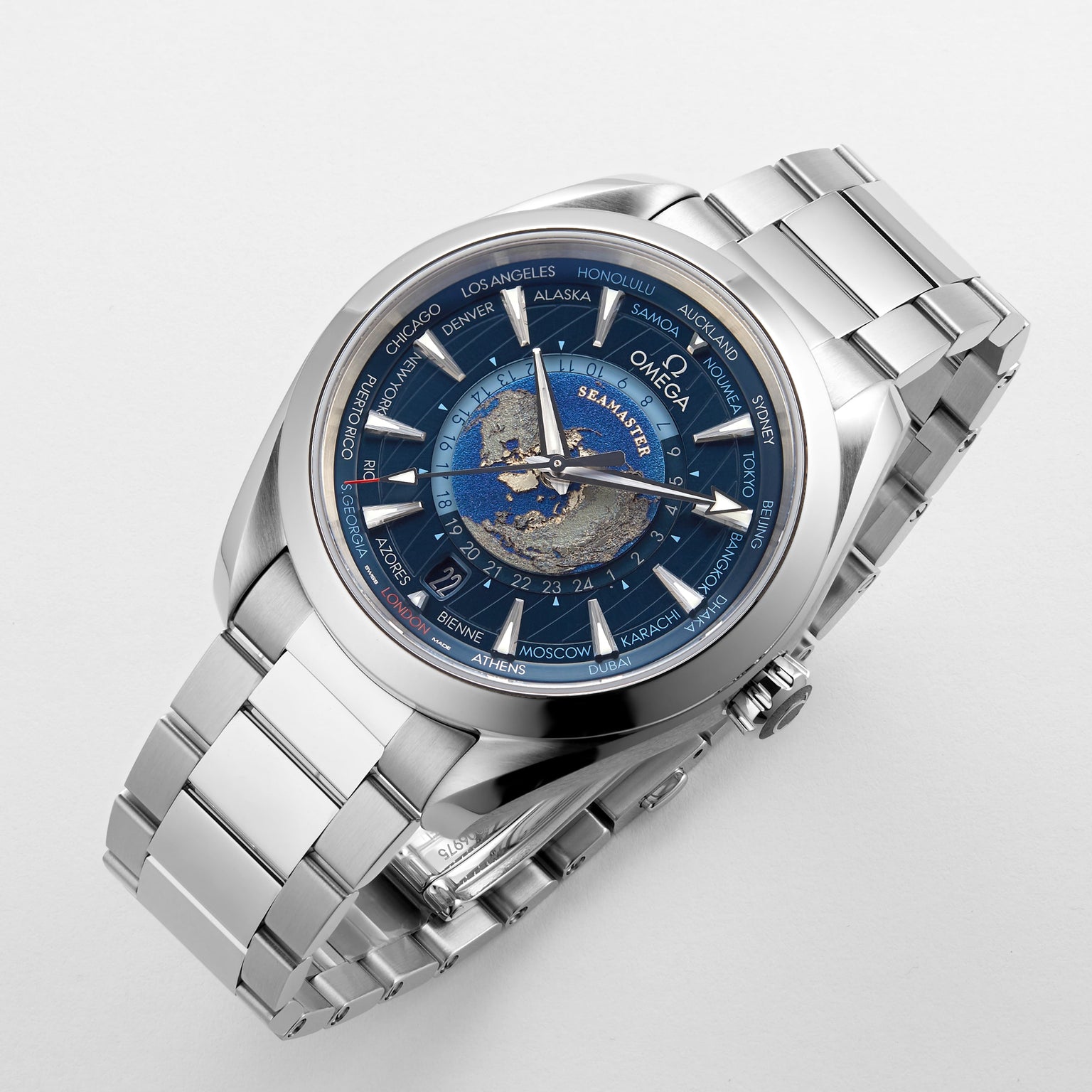 The OMEGA Seamaster Aqua Terra 150M wristwatch features a blue world map dial crafted with laser-ablation technology, silver case, city names around the bezel, and is displayed on a white background.