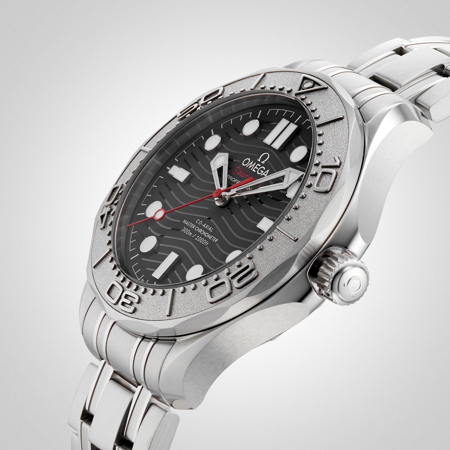 The OMEGA Seamaster Diver 300M Nekton Edition, featuring a stainless steel case, black ceramic wave-pattern dial with large white indexes, date window, and steel bracelet, is displayed on a light background.