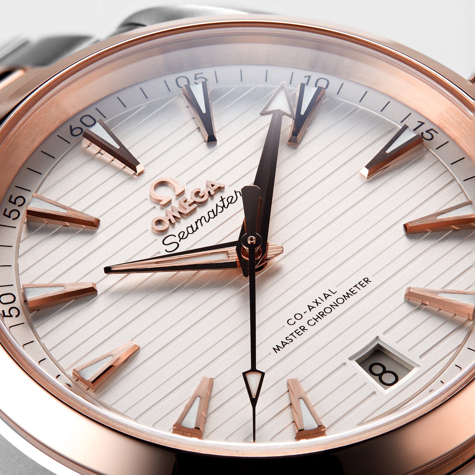 Close-up of the OMEGA Seamaster Aqua Terra 150M with a white textured dial, 18K Sedna™ gold accents, date at 6 o’clock, and time set to 10:10:36. Certified Master Chronometer for outstanding precision.