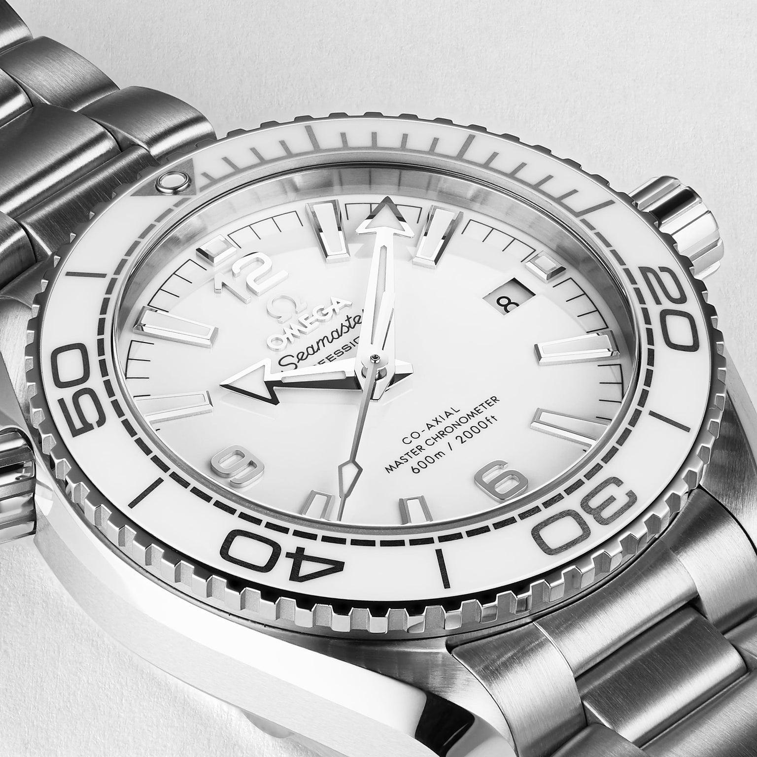 Close-up of a stainless steel OMEGA Seamaster Planet Ocean 600M watch with a white dial, ceramic bezel, silver hour markers, and metal bracelet, displaying the time as 10:09:48.