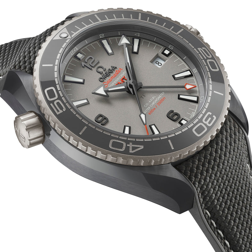 Close-up of the OMEGA Seamaster Planet Ocean 600M wristwatch featuring a textured grey dial, bold hour markers, black bezel, and grey fabric-patterned strap—highlighting its Master Chronometer-certified precision.