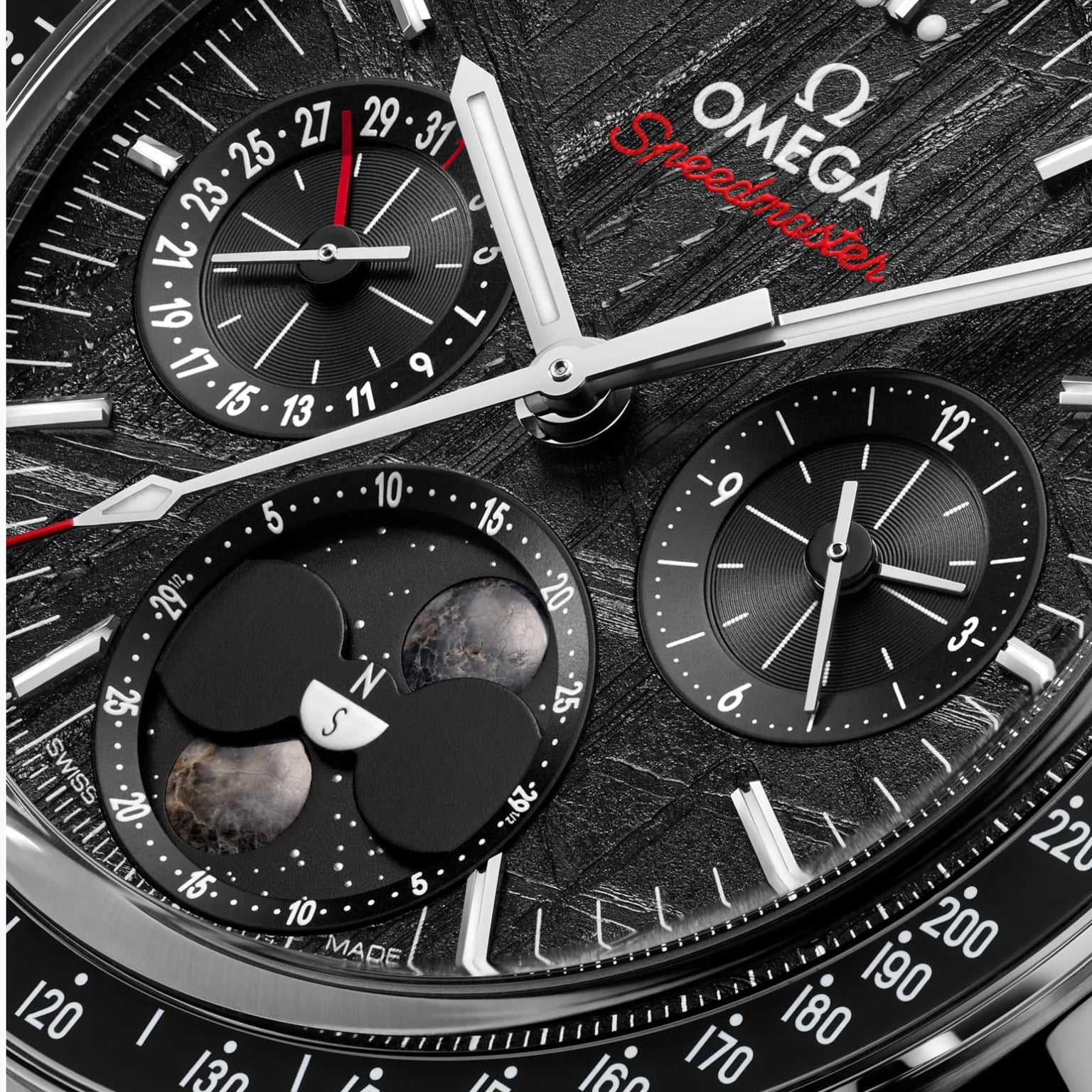 Close-up of the OMEGA Speedmaster Moonphase watch face, showcasing chronograph subdials, date indicators, and a detailed moon phase display inspired by lunar meteorite.