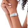 Wearing light pink nail polish, she sports a Longines DolceVita silver rectangular watch with a white Roman numeral dial, radiating elegance and grace.