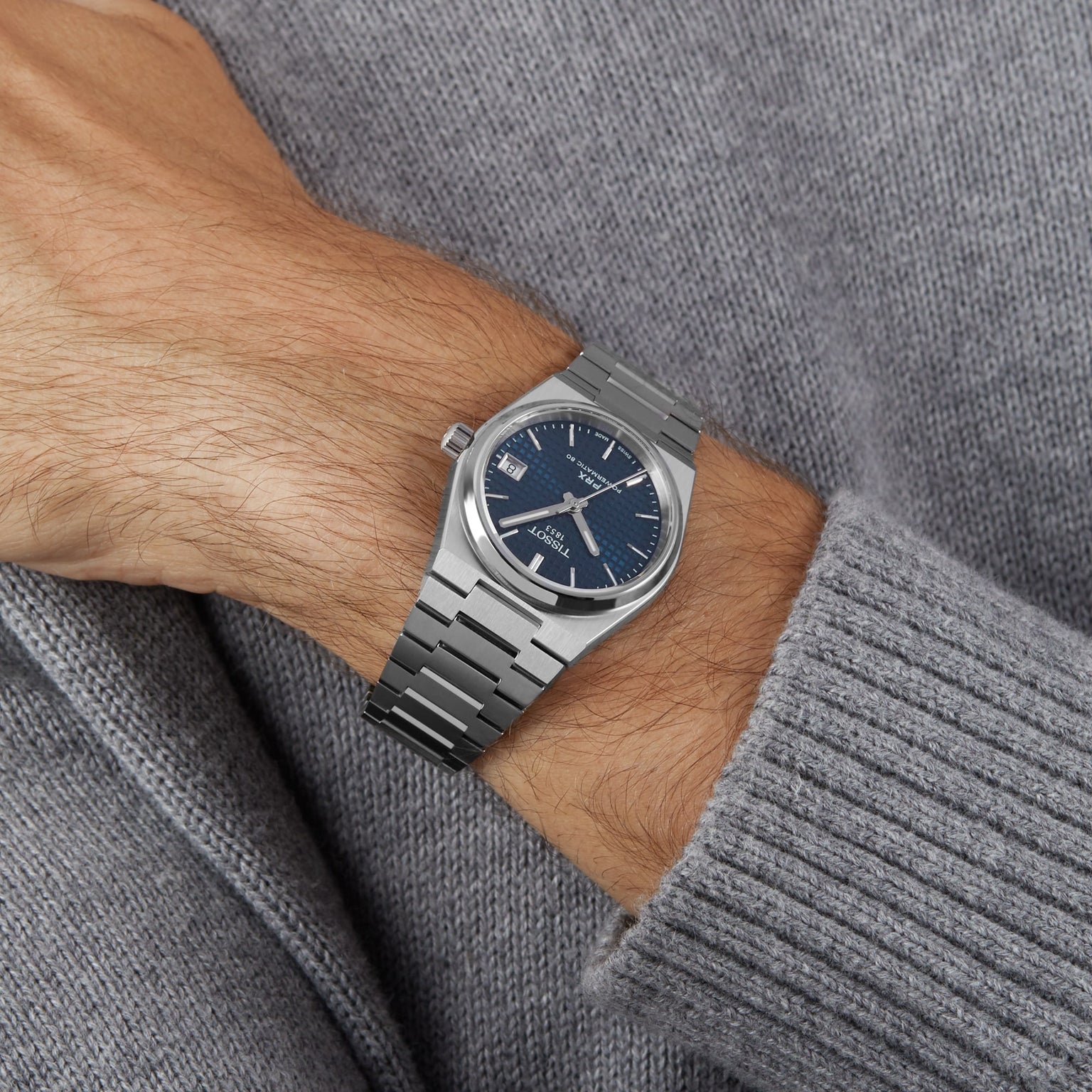 Wrist wearing the Tissot PRX Powermatic 80 watch with a grey sweater
