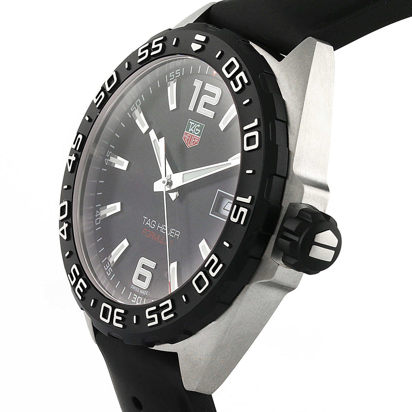 The TAG Heuer Formula 1 Date wristwatch features a black dial with silver hour markers, a date display, black bezel, black rubber strap, and precise quartz movement.