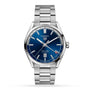 The TAG Heuer Carrera Twin-Time is a stainless steel wristwatch featuring a blue dial, silver hour markers, GMT function, date at 6 o’clock, metal bracelet band, and Carrera Twin-Time Automatic on the watch face.