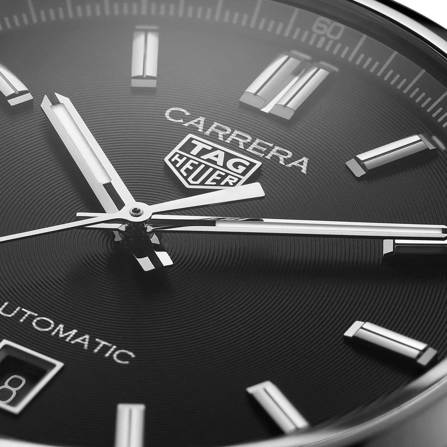 Close-up of the TAG Heuer Carrera Date wristwatch, showcasing a black dial with silver markers and hands, powered by an automatic movement, with the logo and part of the date display visible.