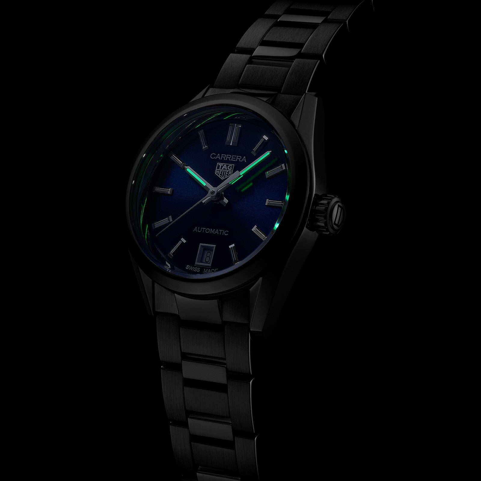 The TAG Heuer Carrera Date wristwatch features a black metal case, blue sunray dial, luminous hour markers, date display, and calibre 9 automatic movement, shown against a black background.