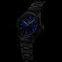 The TAG Heuer Carrera Date wristwatch features a black metal case, blue sunray dial, luminous hour markers, date display, and calibre 9 automatic movement, shown against a black background.
