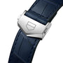 Close-up of a blue alligator leather strap with a silver clasp engraved with a geometric logo, highlighting the refined details of the TAG Heuer Carrera Day-Date timepiece.