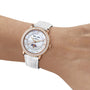 A wrist adorned with the Blancpain Ladybird Quantième Complet, featuring a white leather strap, diamond-set bezel, and an intricate moon phase dial showing date and day.