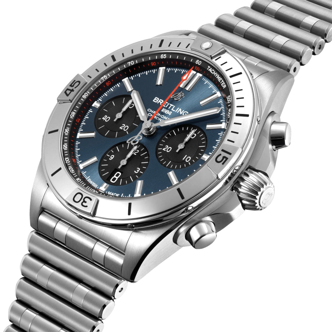 The Breitling Chronomat B01 42 is a stainless steel chronograph watch with a blue dial, three subdials, and a metal link bracelet, featuring the Breitling 01 mechanical movement, shown angled on a white background.