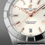 Close-up of the Breitling Chronomat 32 watch face with rose gold hands, diamond hour markers, a date display set to the 30th, and finished with the iconic Rouleaux bracelet.