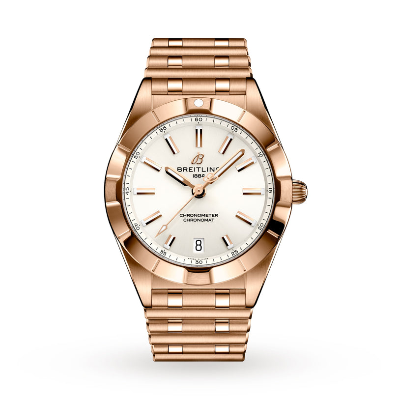 The Breitling Chronomat 32 is a stylish sports watch with a rose gold case, white dial and gold hour markers, date at 6 o’clock, and a matching metal bracelet.