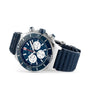 The Breitling Super Chronomat B01 44 is a stainless steel mechanical chronograph featuring a blue dial with three subdials, a rotating bezel, and a textured blue rubber strap.