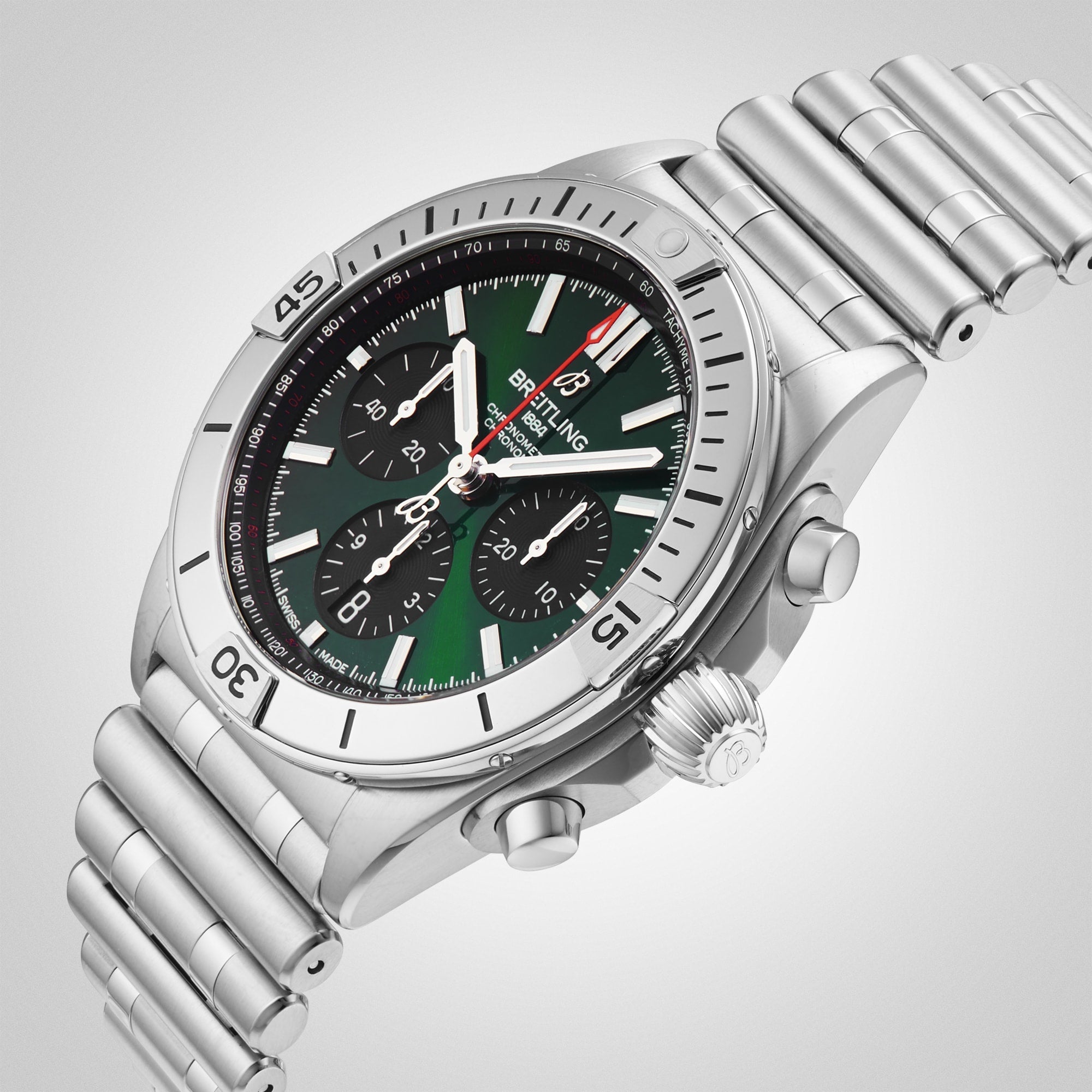 The Breitling Chronomat B01 42 wristwatch features a silver stainless steel case and bracelet, green dial with three subdials, black bezel markers, displayed at an angle on a light gradient background.