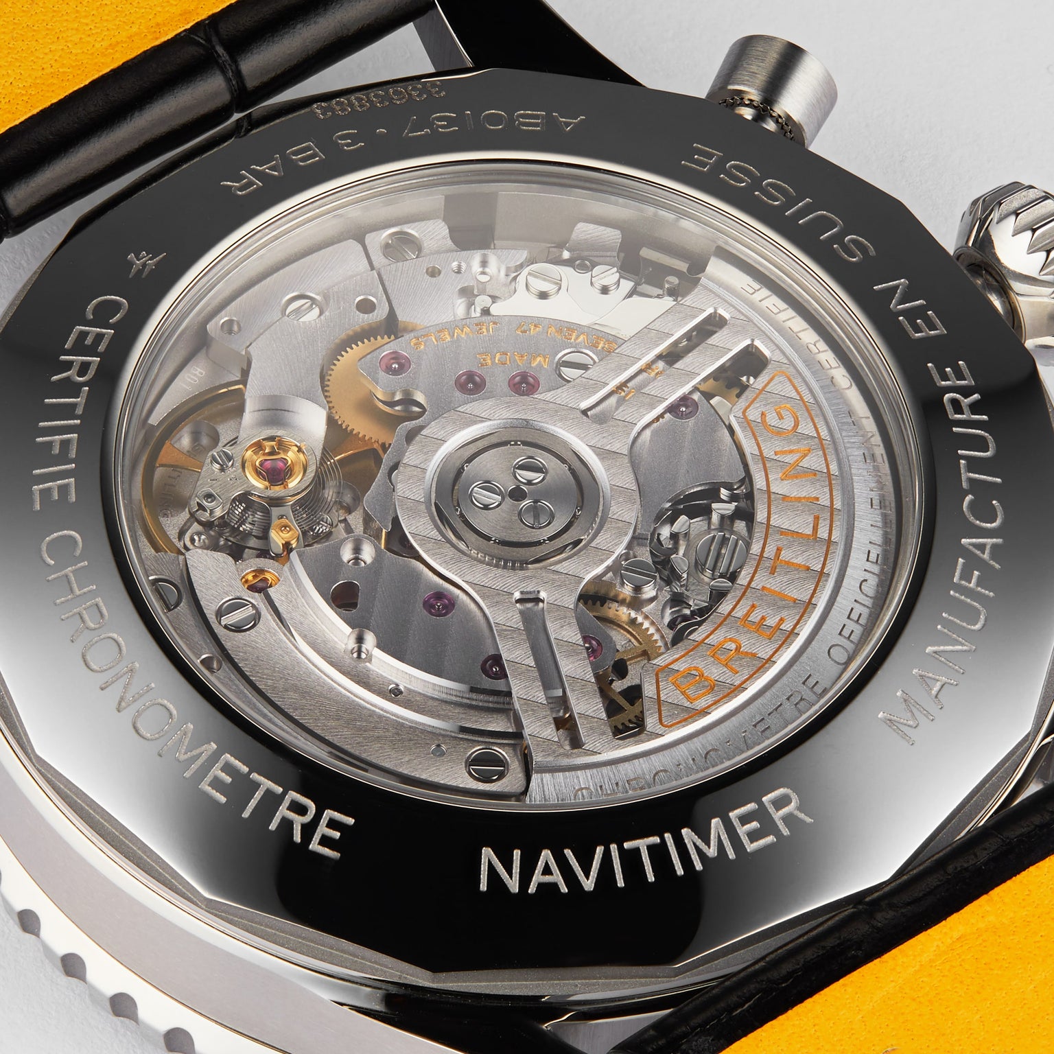 Close-up view of the transparent case back of the Breitling Navitimer B01 Chronograph 46, showcasing its intricate mechanical movement and engraved text on the outer rim.