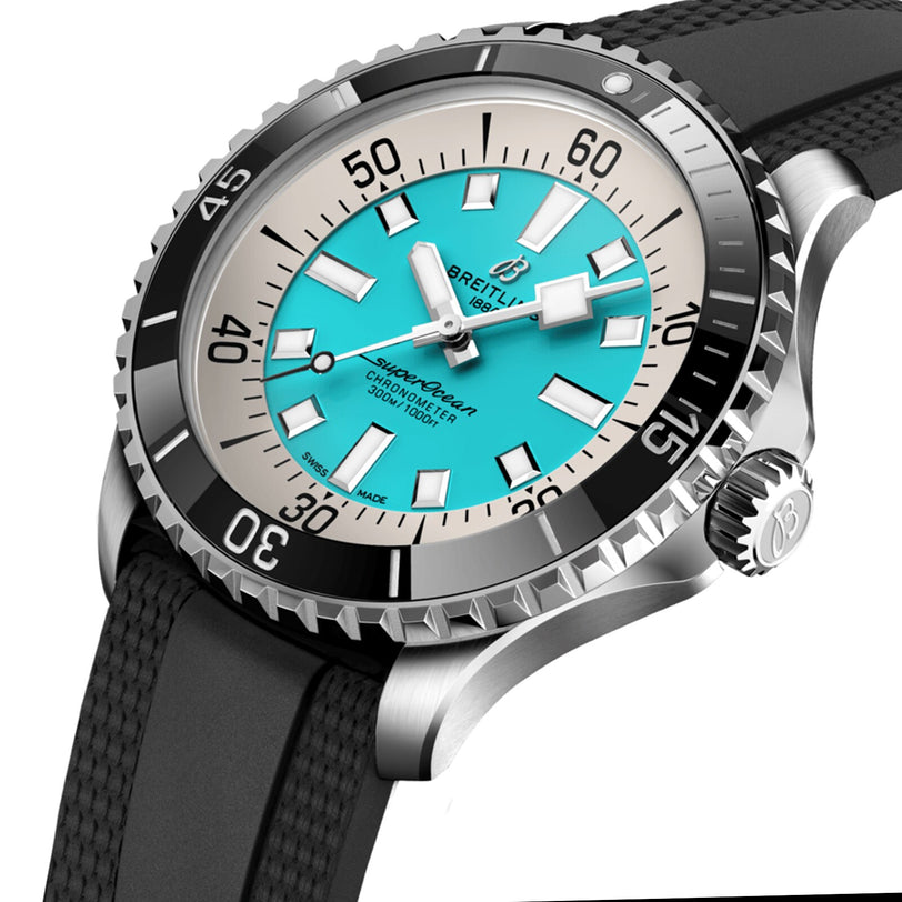 Close-up of the Breitling Superocean Automatic 44 dive watch with a turquoise dial, black bezel, stainless steel case, and black textured rubber strap.