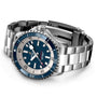 The Breitling Superocean Automatic 42 is a stainless steel dive watch with a blue and silver bezel, dark blue dial with Super-LumiNova accents, metal bracelet, and displays the Breitling logo with Chronometer text.