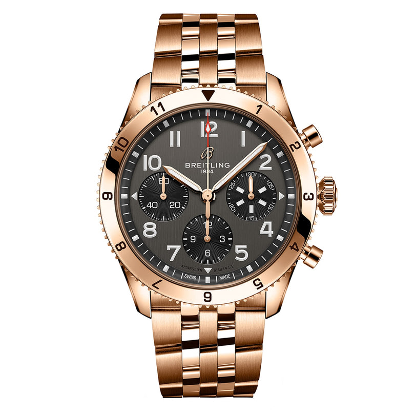 The Breitling Classic AVI Chronograph 42 P-51 Mustang features a gold case, black dial with three subdials, and a metal link bracelet, shown against a white background.