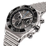 The Breitling Super Chronomat B01 44, a stainless steel chronograph with black tachymeter bezel, three subdials, and link bracelet, is shown at an angle and powered by the precise Breitling 01 calibre.
