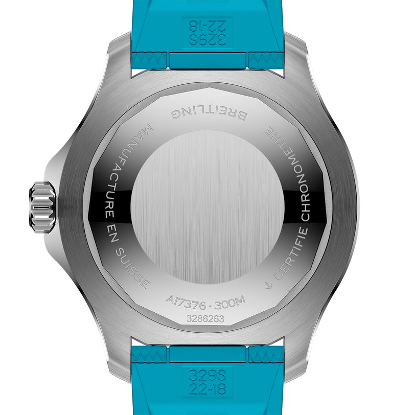 The back of the stainless steel Breitling Superocean Automatic 44 has detailed engravings, a turquoise rubber strap, and a visible crown on the left side.
