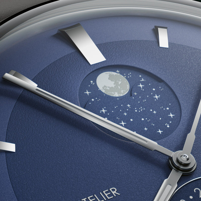 Watch dial with blue face featuring moonphase complication displaying full moon and stars, silver hands and hour markers.