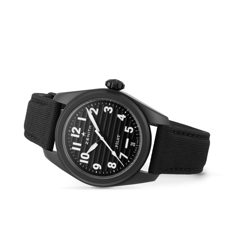 The Zenith Pilot Automatic wristwatch features a black textured dial with white numerals, a black fabric strap, and an automatic high-frequency movement, all showcased against a white background.