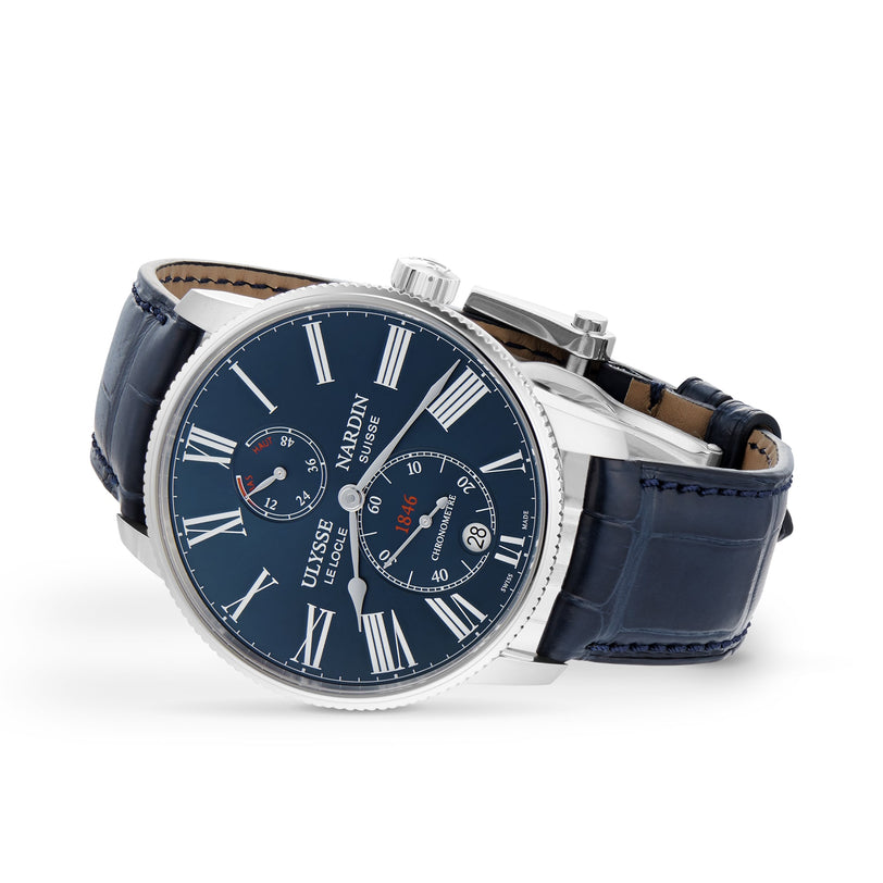The Ulysse Nardin Marine Torpilleur features a blue leather strap, blue dial, white Roman numerals, and two subdials for time and date—an elegant luxury timepiece.