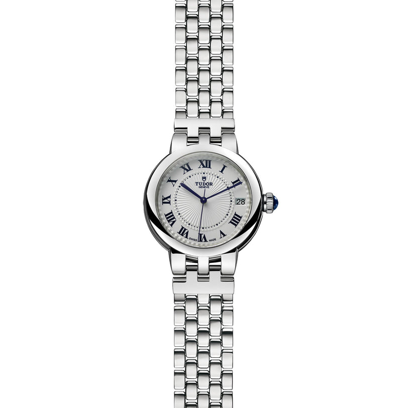 TUDOR Clair de Rose wristwatch with Roman numeral markers, date display, and metal link bracelet on a white background.