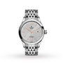 A TUDOR 1926 silver ladies’ wristwatch featuring a textured light gray dial, gold hour markers, self-winding movement, date at 3 o’clock, and metal link bracelet shown on a white background.