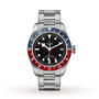 The TUDOR Black Bay GMT wristwatch features a stainless steel band, black dial, date window, and a distinctive red and blue 24-hour bezel inspired by classic diving watches.