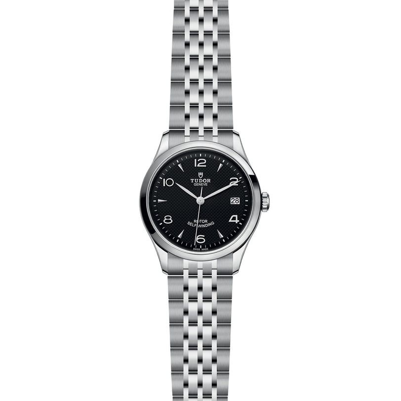 The TUDOR 1926 is a stainless steel wristwatch with a black dial, silver hour markers, date at 3 o’clock, and a linked metal bracelet—ideal for fans of classic mechanical watches.