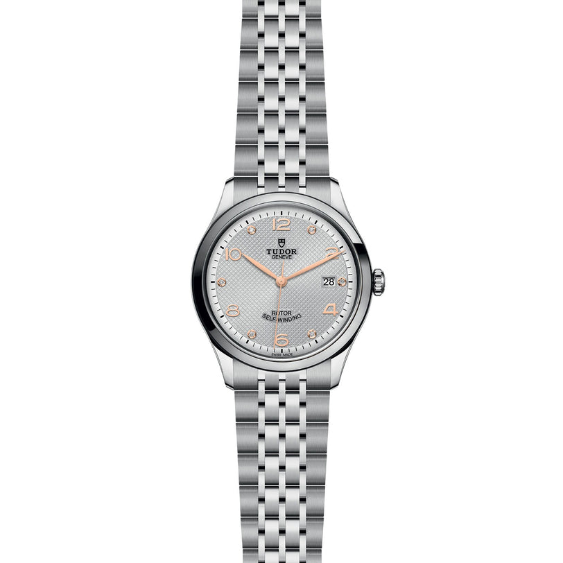 The TUDOR 1926 wristwatch features a silver metal link band, a white dial, and gold hour markers, shown on a white background.