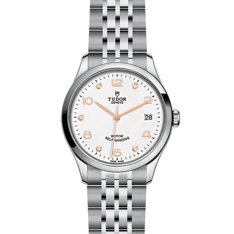 The TUDOR 1926 wristwatch features a silver metal bracelet, white textured dial, gold hour markers and hands, plus a date window at 3 oclock—a refined homage to classic mechanical timepieces.