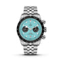 The TUDOR Black Bay Chrono features a stainless steel case, turquoise dial, black bezel, three subdials, date at 6 o’clock, Swiss Chronometer rating, and a silver metal bracelet.
