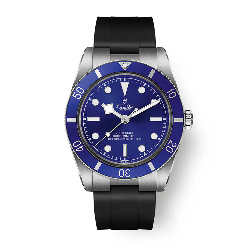 Tudor watch with stainless steel case, blue dial, blue rotating bezel, and black rubber strap.