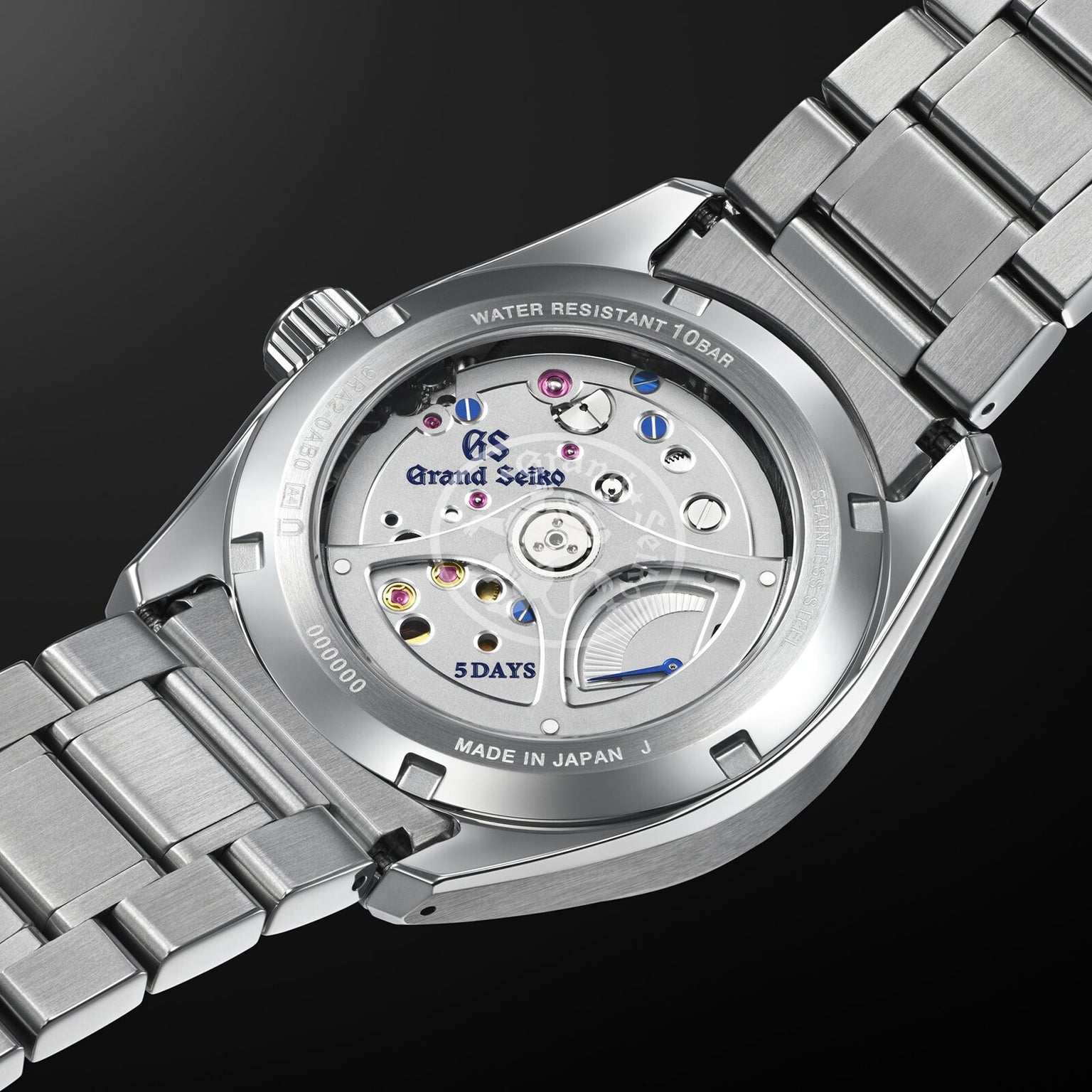 Close-up of the Grand Seiko Spring Drive 5 Days Evolution 9 wristwatch’s back, showcasing its Spring Drive movement through a transparent case with engraved branding and 5 DAYS power reserve—an elegant nod to Japanese craftsmanship.