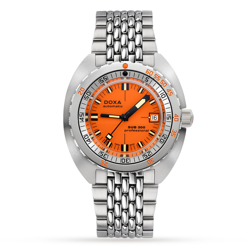 The DOXA Sub 300 Professional is a stainless steel diver’s watch featuring an orange dial, black markers, date at 3 o’clock, unidirectional bezel, silver metal bracelet, and “DOXA automatic SUB 300 professional” on the dial.