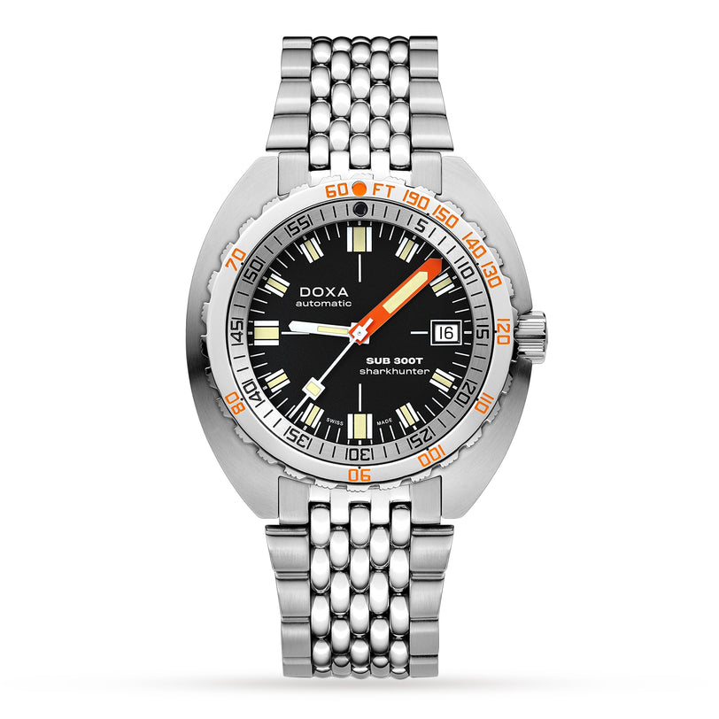 The DOXA Sub 300T Sharkhunter is a stainless steel divers watch with a black dial, orange and white Super-LumiNova markers, date display, and a metal bracelet.