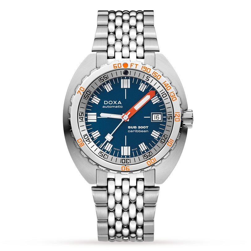 The DOXA Sub 300T Caribbean is a stainless steel automatic divers watch with a blue dial, orange and white accents, date display, metal bracelet, and a helium release valve for professional underwater use.