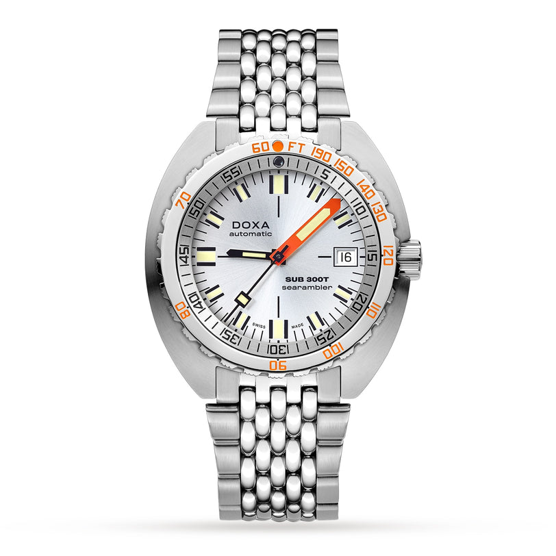 The DOXA Sub 300T Searambler is a stainless steel divers watch featuring a silver dial, orange minute hand, black hour hand, date window at 3 o’clock, scratch-resistant sapphire crystal, and a multi-link bracelet.
