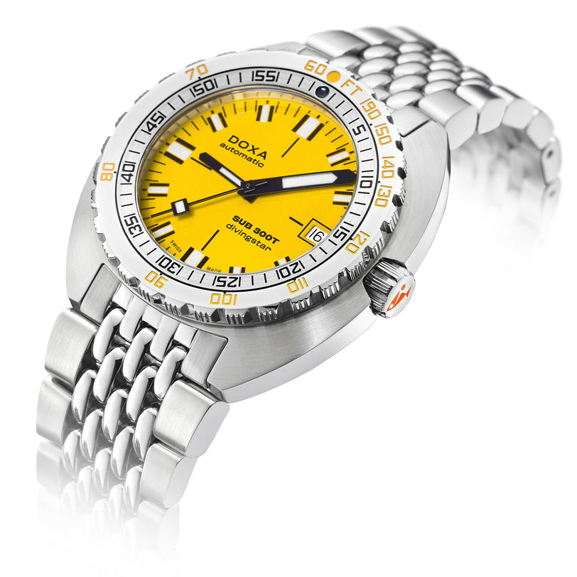 The DOXA Sub 300T Divingstar is a stainless steel diver’s watch with a yellow dial, black and orange accents, metal bracelet, and a helium release valve. The face reads “DOXA automatic Sub 300T Divingstar.”.