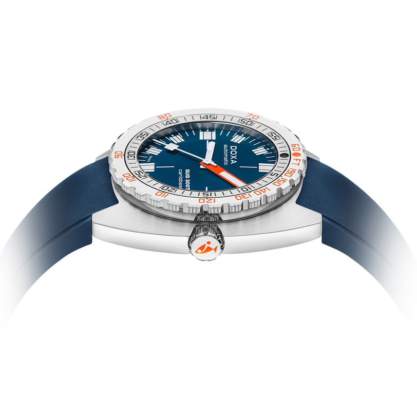 A close-up side view of the DOXA Sub 300T Caribbean divers watch, featuring a blue strap, silver bezel, blue dial, orange-tipped hands, and a rugged design rated to 120 bar.