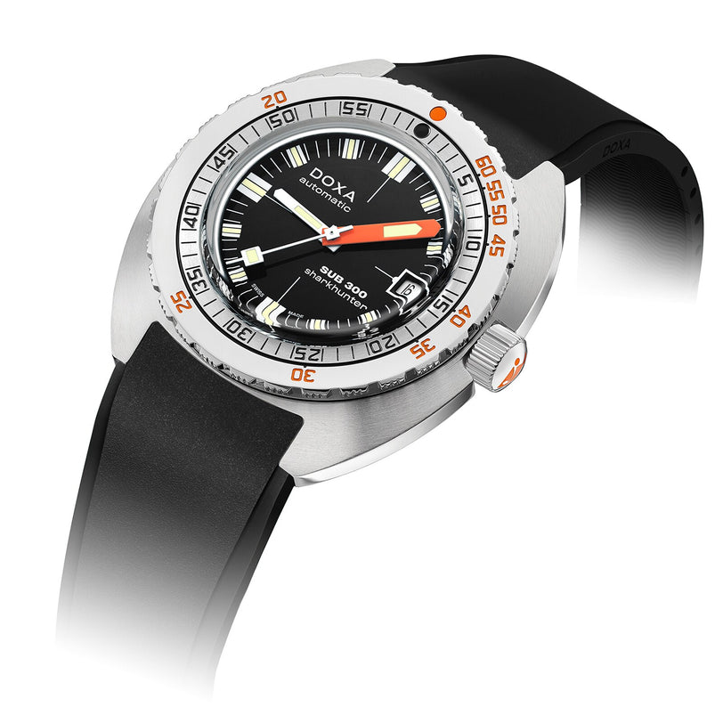 The DOXA Sub 300 Sharkhunter is a stainless steel divers watch featuring a black dial with orange accents, unidirectional bezel, date display, and a black rubber strap.